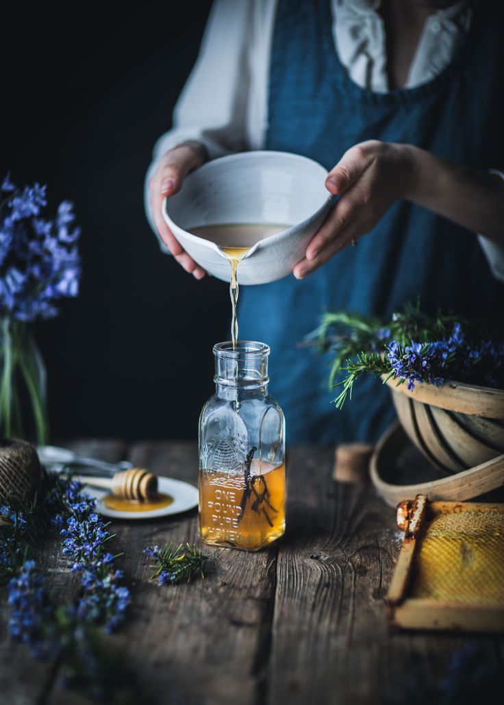 Natural oil being poured by hand into a glass bottle